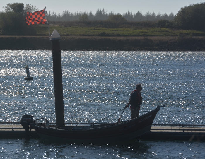 fisherman and motorboat in silhouette